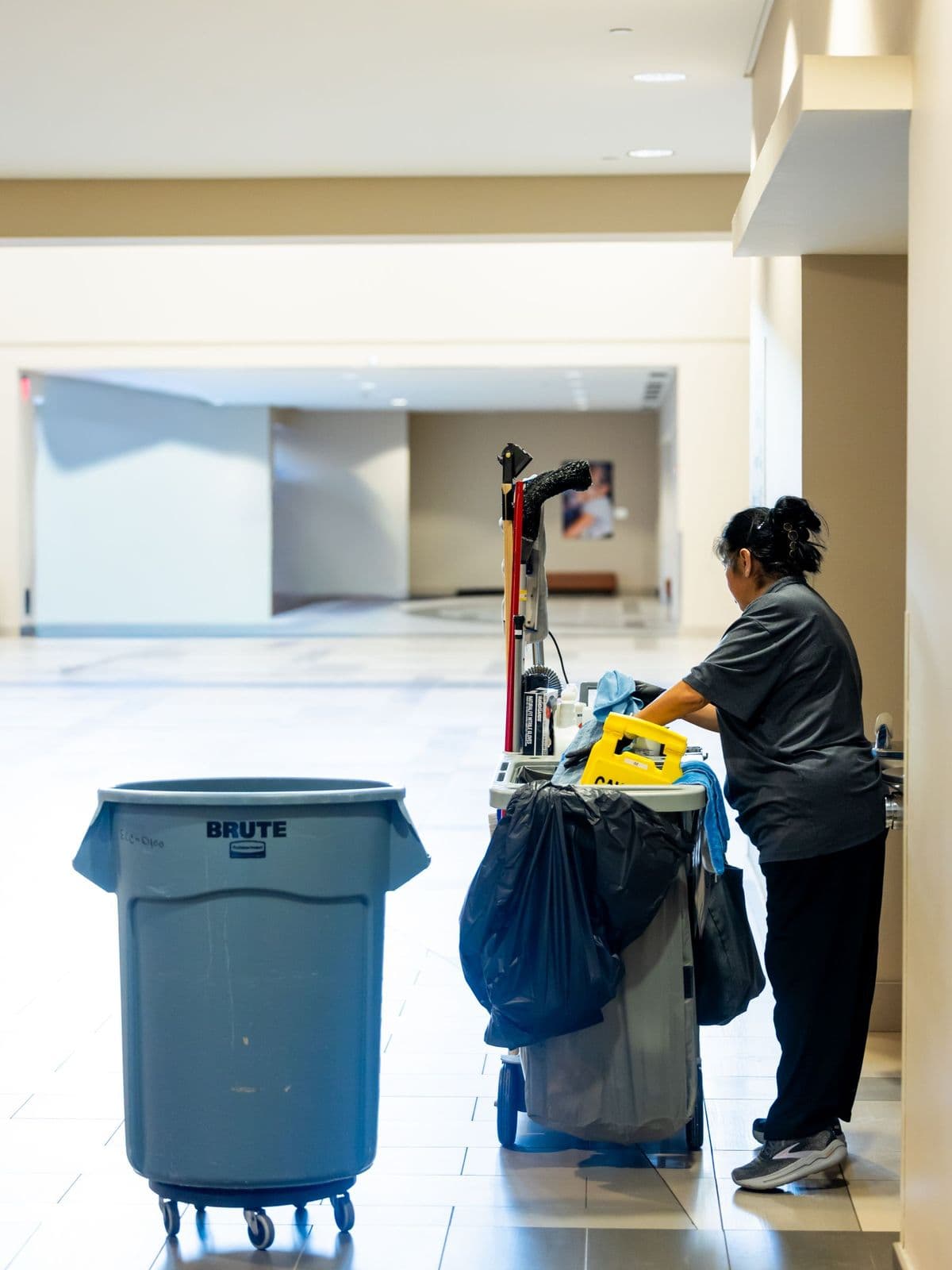 Janitorial cart with supplies in a commercial building hallway
